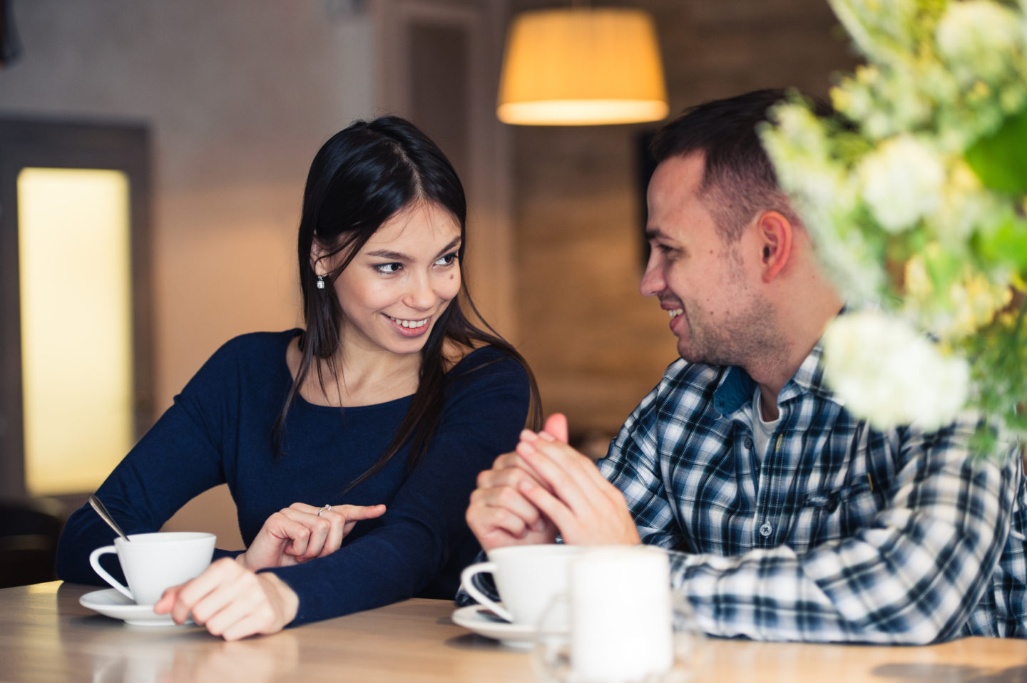 Une femme et un homme prennent un café et discutent en souriant
