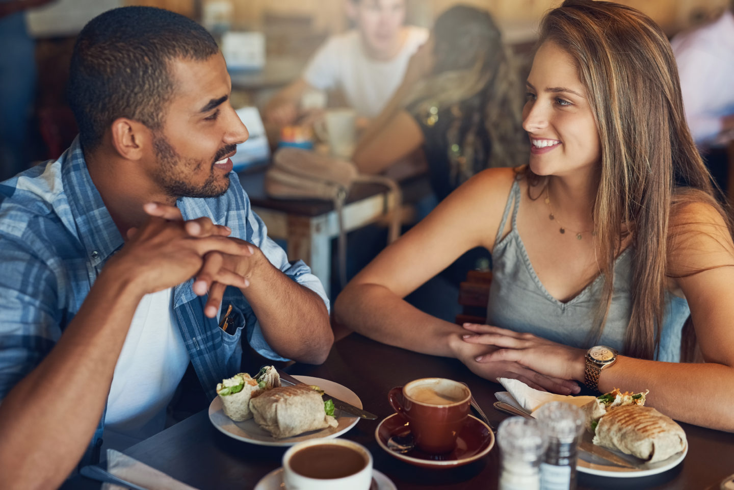 Un homme et une femme sont au restaurant et discutent en souriant