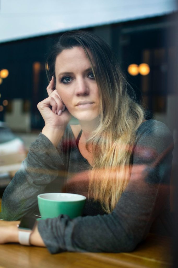 Une femme triste et pensive, seule dans un café