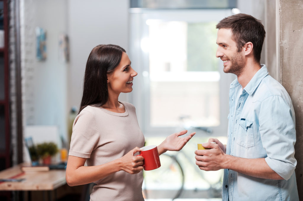 Deux célibataires font connaissance, une tasse de café à la main.