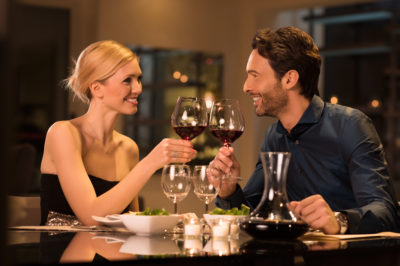 Une femme et un homme trinquent dans un restaurant chic. Qui va payer la note ?