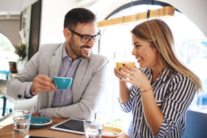 Un homme et une femme discutent en souriant dans un café