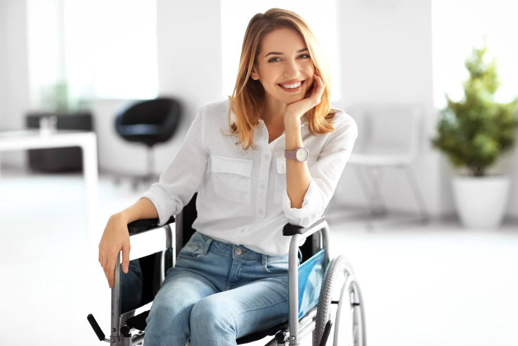 Une femme en fauteuil roulant fait un grand sourire