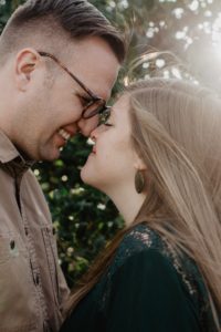 Une homme et une femme se touchent le visage par le nez, en souriant